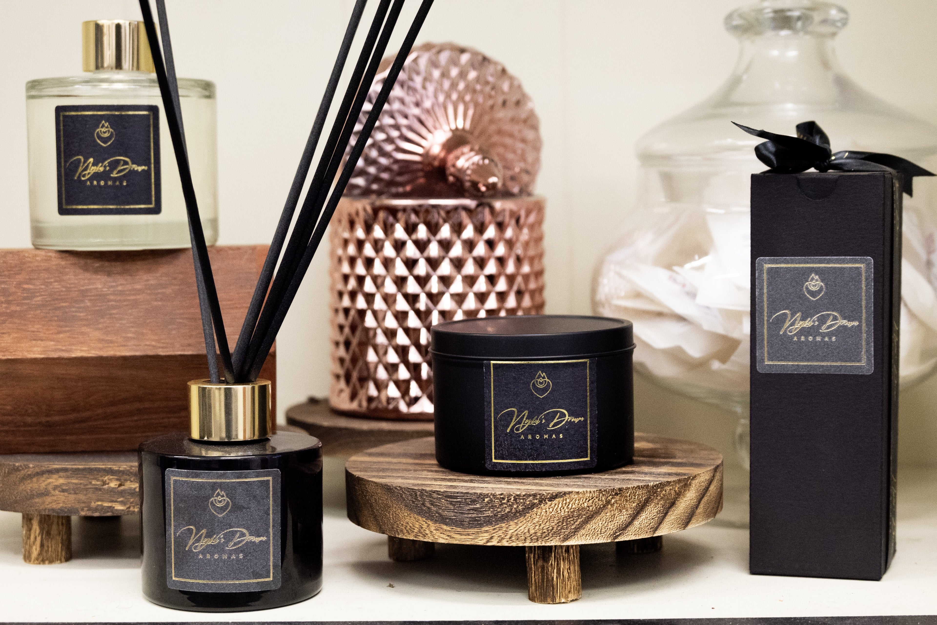 Candles and diffusers on a wooden surface with decorative items.